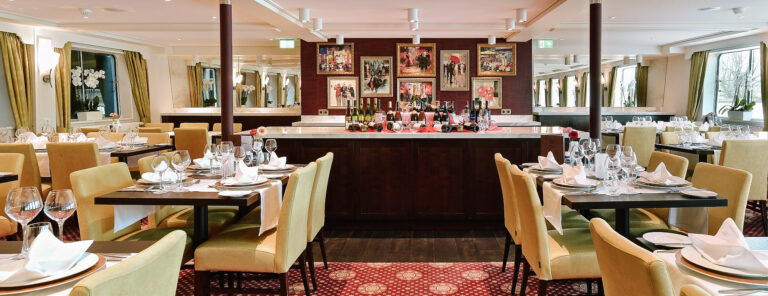 Interno di un ristorante su una nave da crociera, atmosfera accogliente.